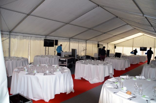 Mise en place des tables avec nappes et serviettes en tissu.